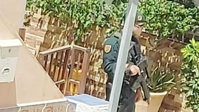Uno de los agentes de la Guardia Civil en la zona donde un hombre se ha atrincherado con un arma en Mijas (Málaga).