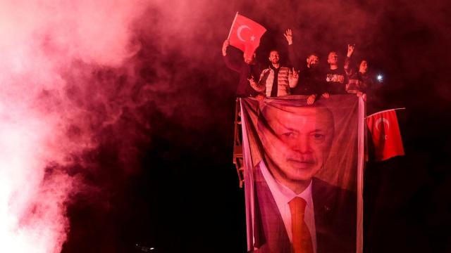 Un grupo de hombres despliega una bandera con la cara de Erdogan, este domingo en Ankara.