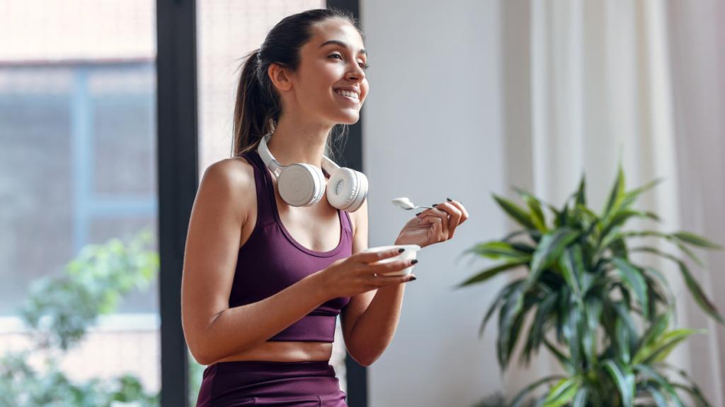 Imagen de archivo de una mujer comiéndose un yogur tras ejercitarse.