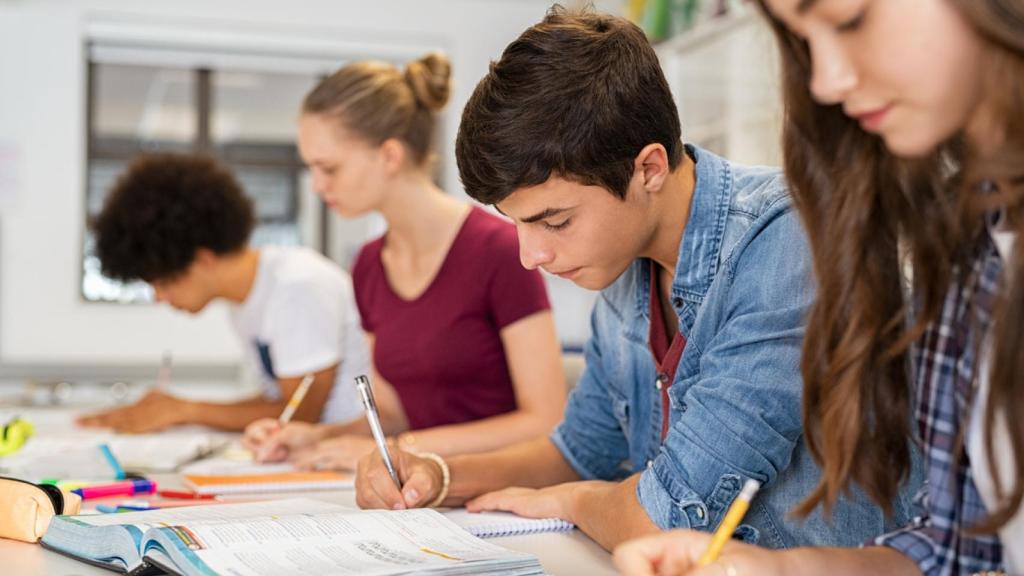 Un joven haciendo un examen en clase.