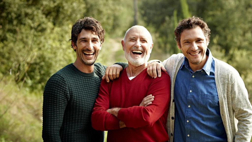 Tres amigos de diferente edad comparten un momento de felicidad.
