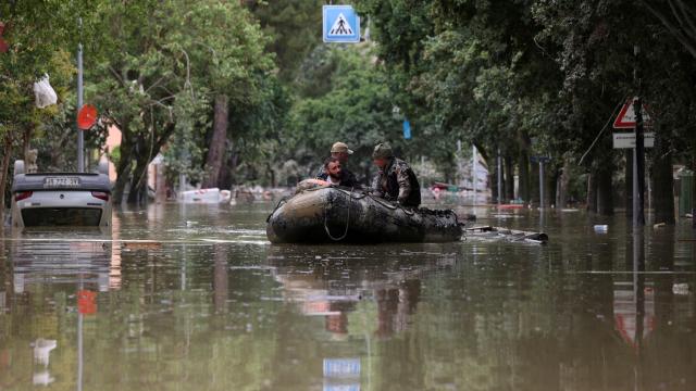 Dos militares ayudan a una persona tras las inundaciones en Emilia Romagna, en Italia.