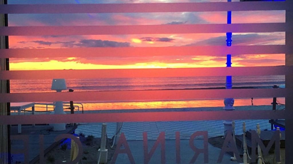 Puesta de sol a través del cristal de este local hostelero del paseo de Samil