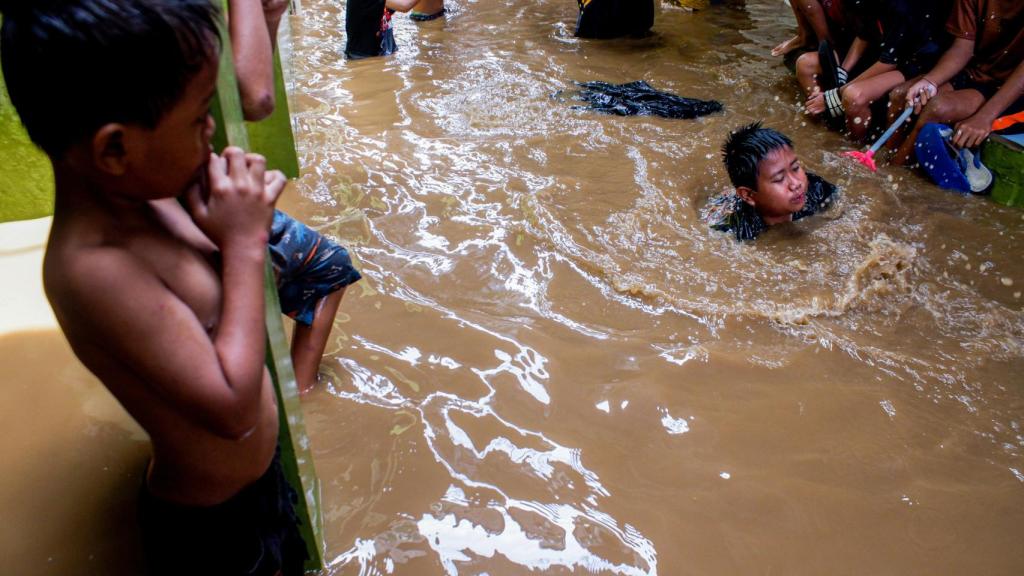 Niños indonesios juegan en un callejón inundado en Yakarta tras las inundaciones de octubre de 2020.