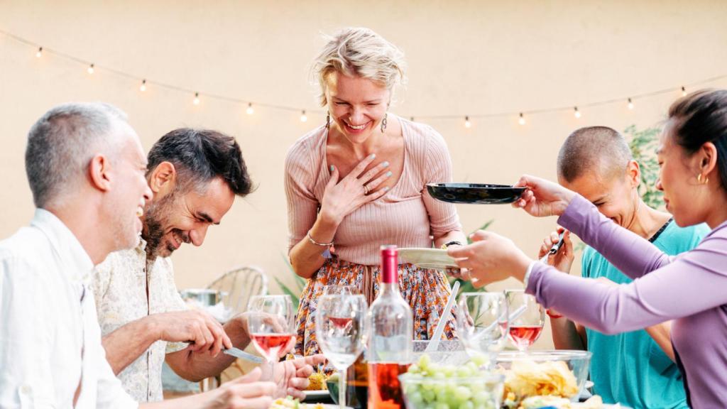 Imagen de archivo de un grupo de amigos compartiendo comida y bebida.