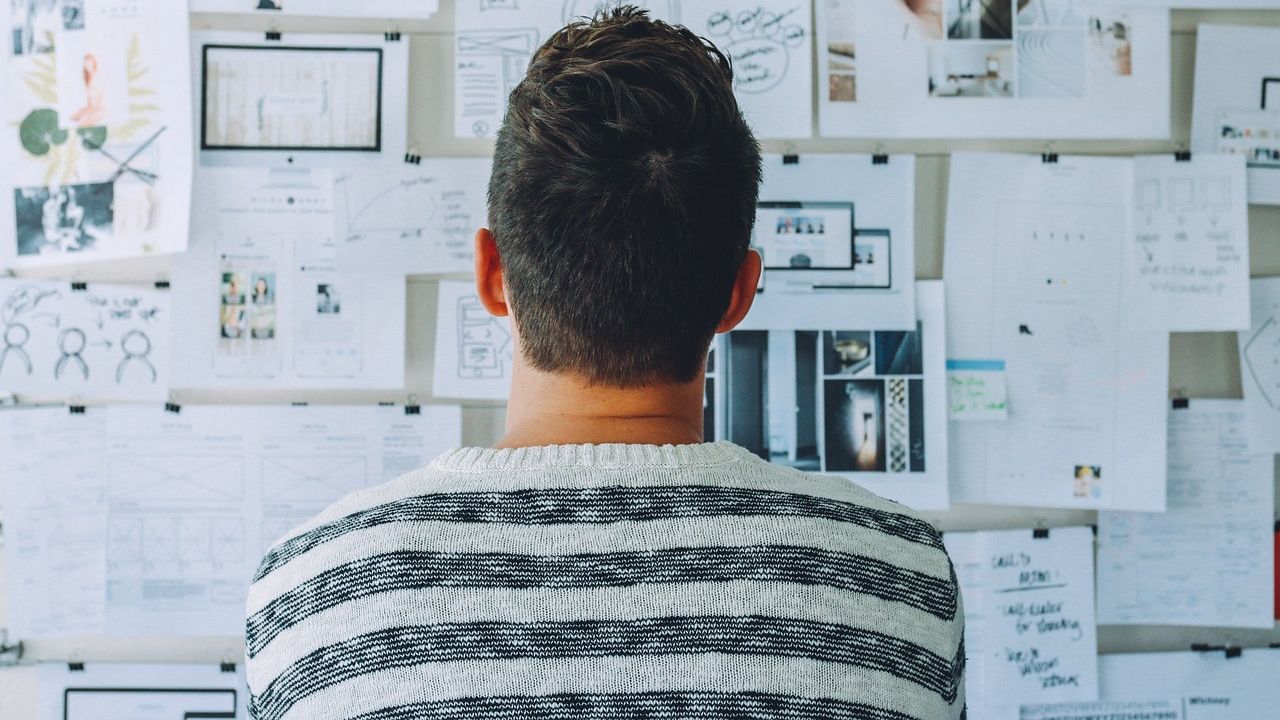 Un joven, ante un panel con información sobre el negocio. FOTO: Pixabay.