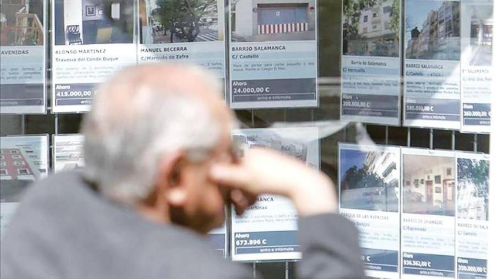 Una persona frente a una inmobiliaria, en imagen de archivo.