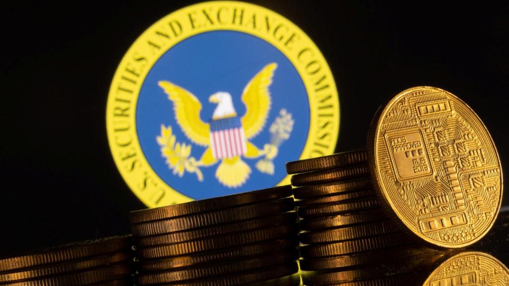Representación física de unas criptodivisas sobre un logo de la Comisión del Mercado de Valores de Estados Unidos (SEC, en inglés).