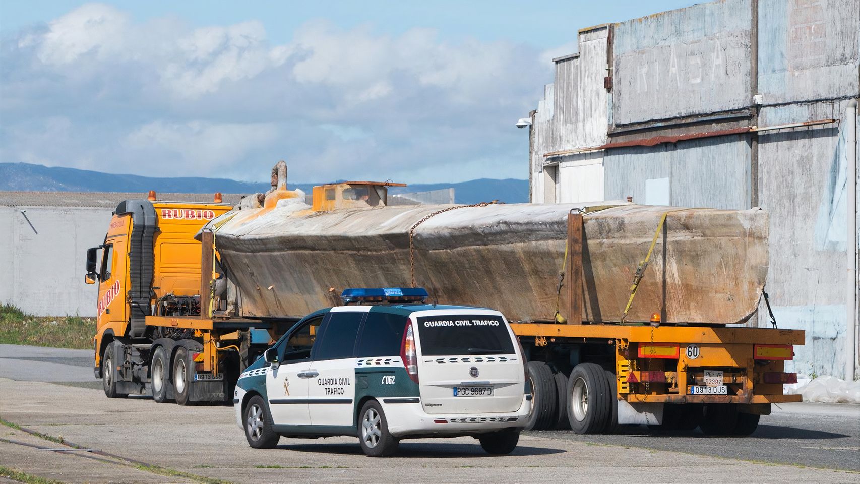 El narcosubmarino hallado en la ría de Arousa, a su llegada a un muelle del puerto de Vilagarcía (Pontevedra), en un transporte especial escoltado por la Guardia Civil.