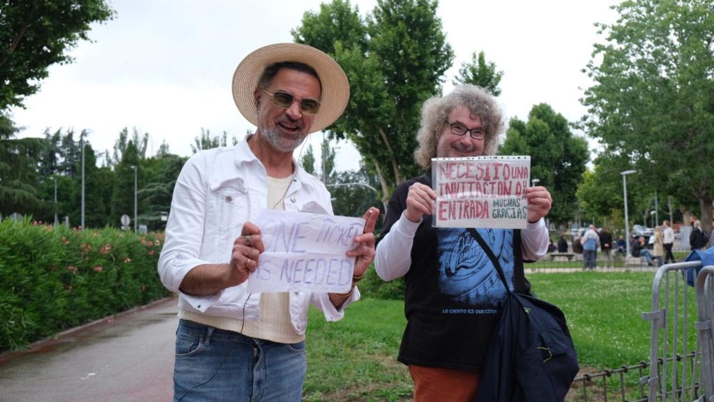 Dos personas tratando de encontrar entradas de reventa.