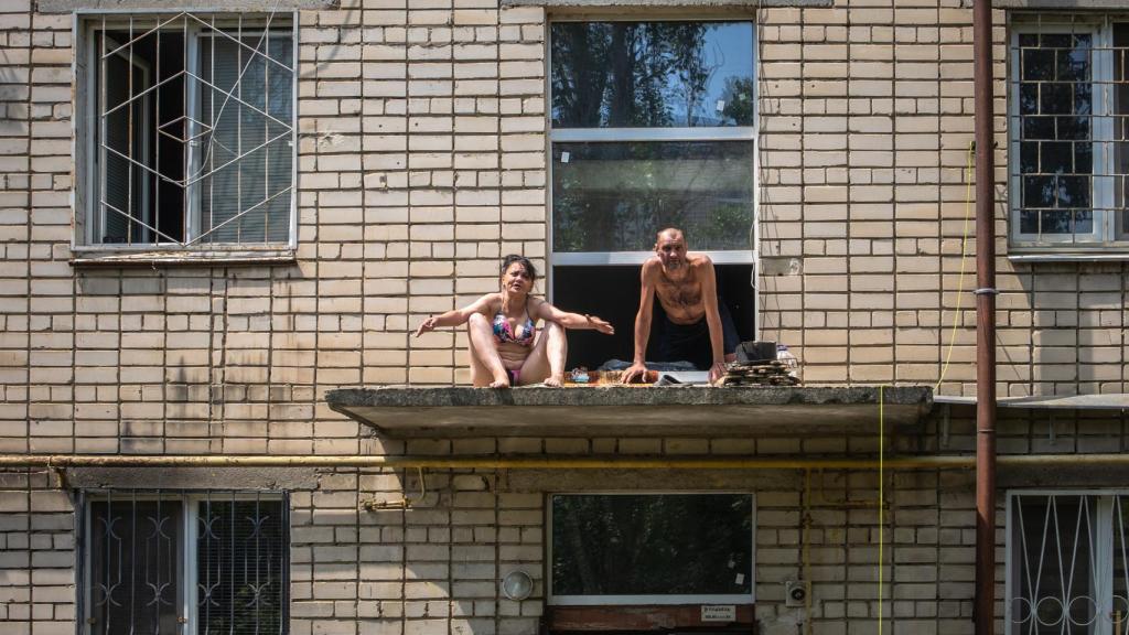 Tomando el sol en el pequeño techo del portal, así pasan algunos vecinos de Jersón los primeros días de inundaciones.