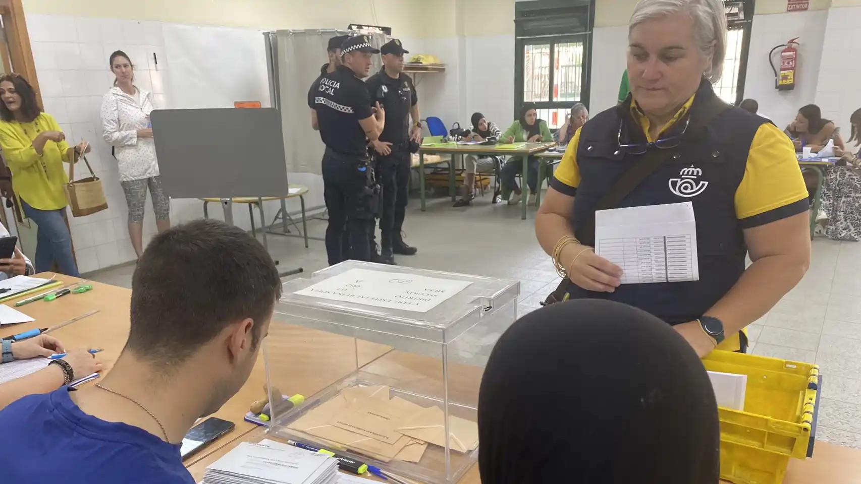 Una empleada de Correos en una mesa electoral.