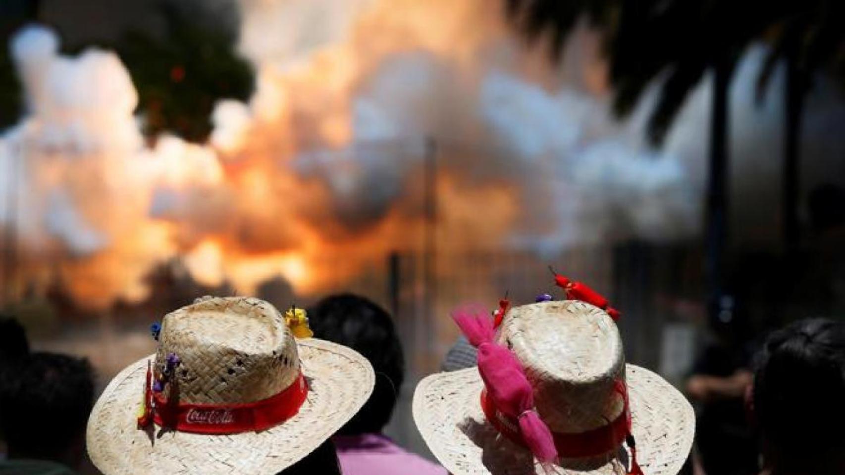 Dos personas observan una mascletá de Hogueras, en imagen de archivo.