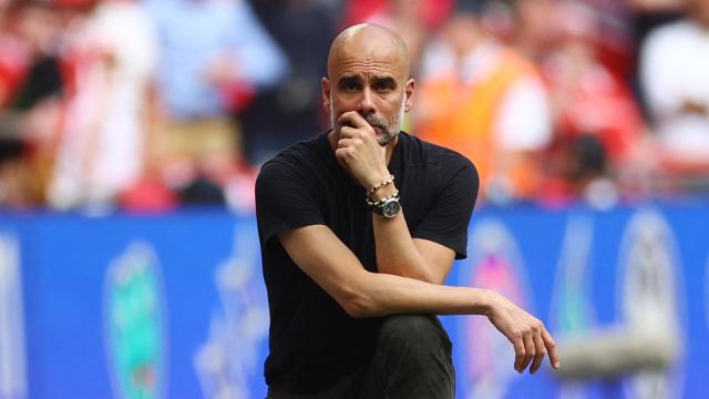 Pep Guardiola, pensativo en la banda durante un partido.