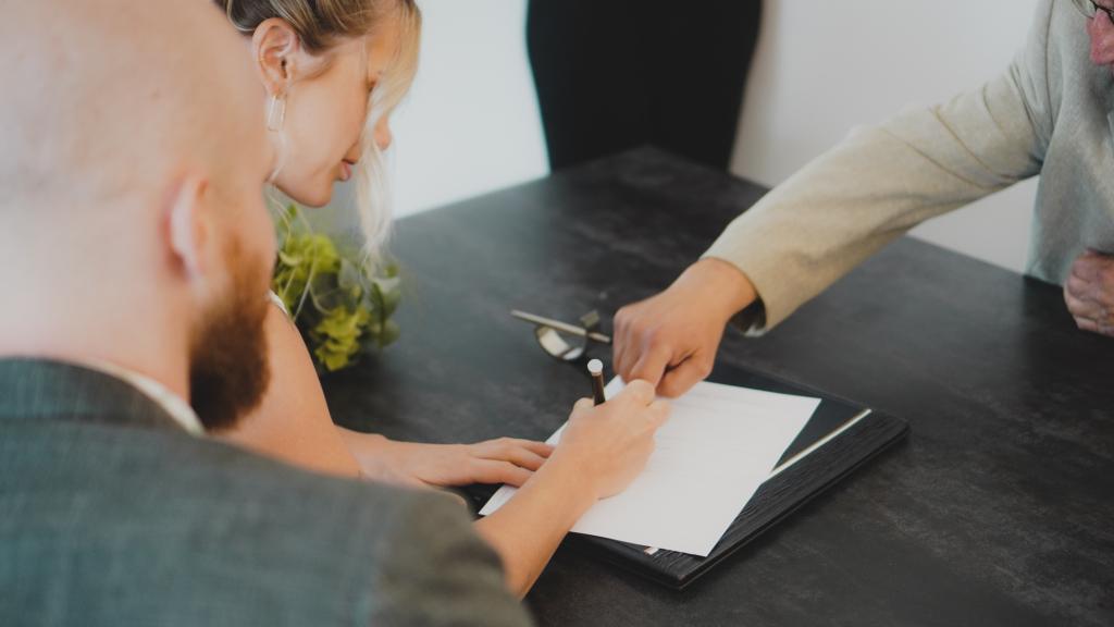 Una pareja firmando una herencia.