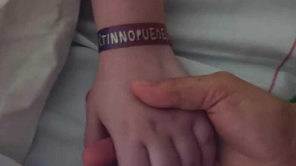 Isabel sujetando la mano de su hijo, Martín.
