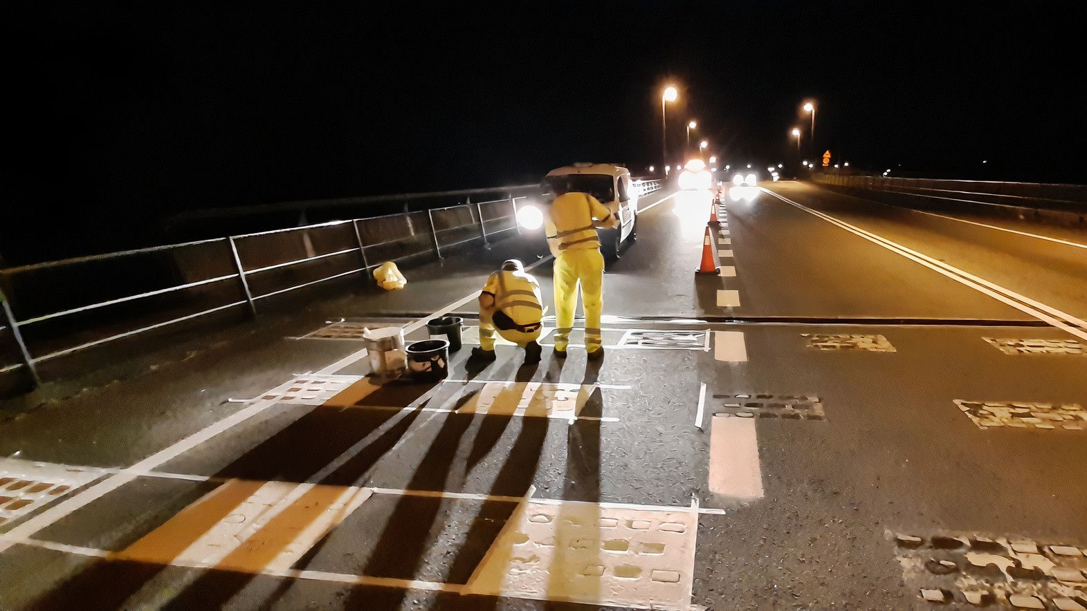 Dos operarios realizan obras de reparación en un vial.