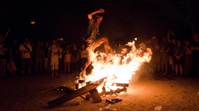 Un hombre salta una hoguera de San Juan.