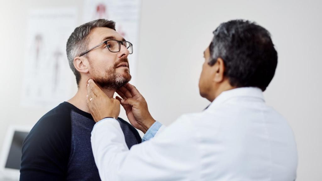 Un hombre con su médico haciéndose chequeo.