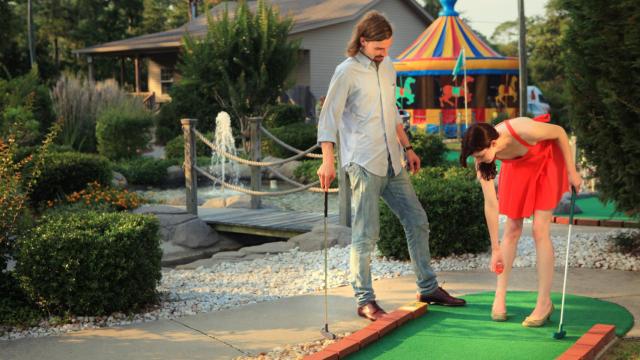 Una pareja jugando al minigolf.
