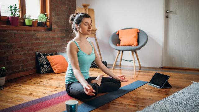 Una mujer haciendo yoga con una aplicación digital.