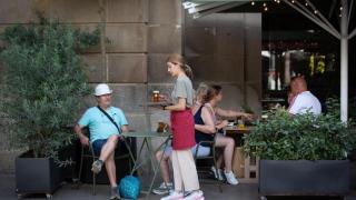 Una camarera sostiene una bandeja en la Plaza Real de Barcelona.