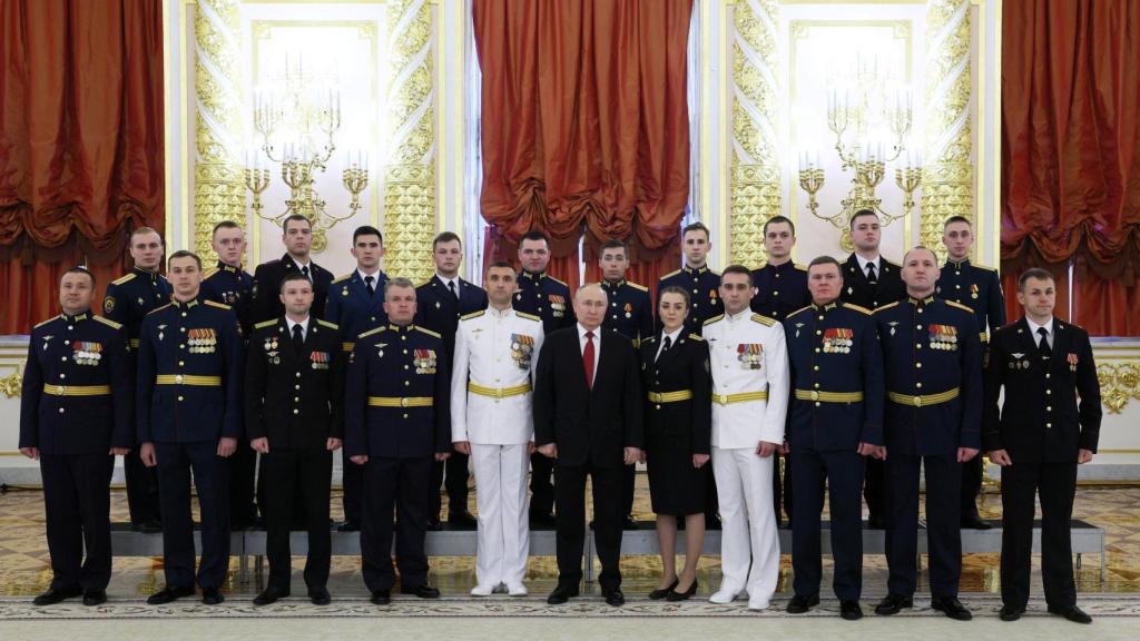 Vladimir Putin posa para una foto con graduados de las instituciones militares de educación superior de Rusia durante una reunión en el Kremlin.