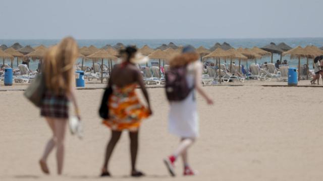 Varias personas entran en una playa valenciana, este miércoles.