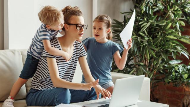 Imagen de archivo de una mujer intentando trabajar con sus hijos en casa.