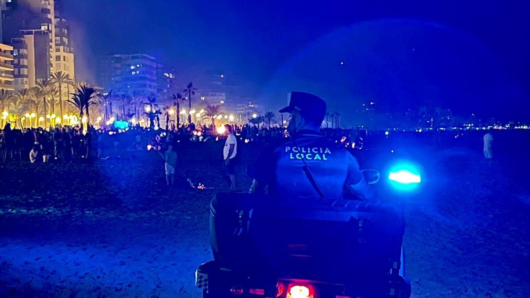 Un agente de Policía Local controlando una playa de Alicante en una noche de San Juan, en imagen de archivo.