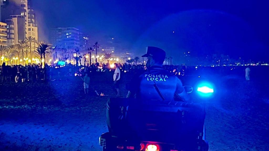 Un agente de Policía Local controlando una playa de Alicante en una noche de San Juan, en imagen de archivo.