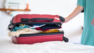 Imagen de archivo de una maleta que está lista para cerrarse.