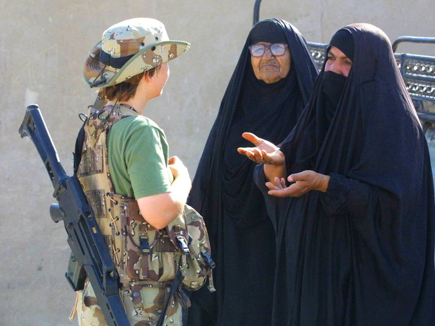 Una militar española junto a dos mujeres en una operación internacional.