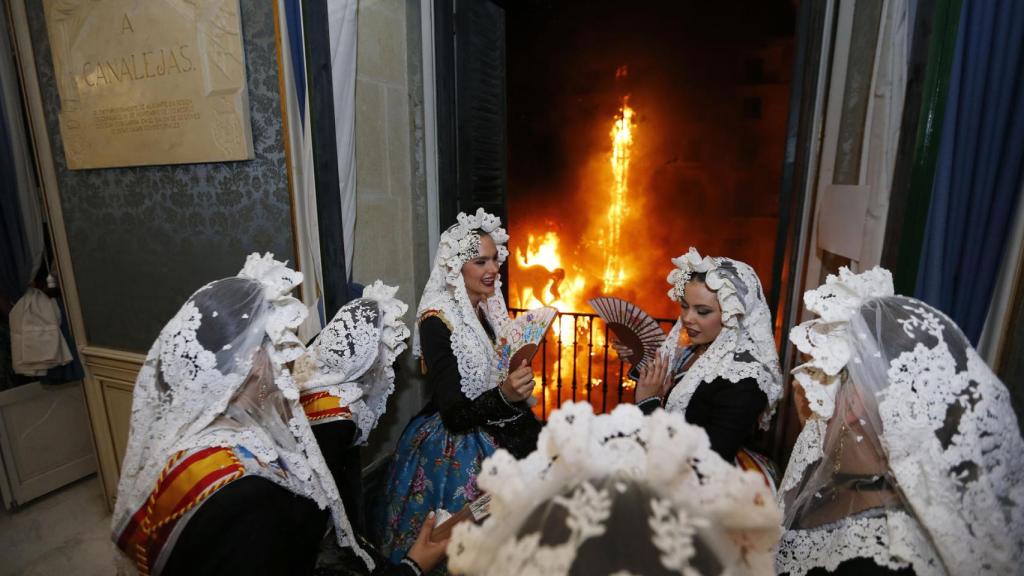 La Bellea del Foc y sus Damas miran como la Hoguera Oficial arde desde el balcón del Ayuntamiento.