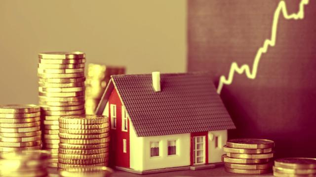 Maqueta de una casa sobre unas monedas de euro.