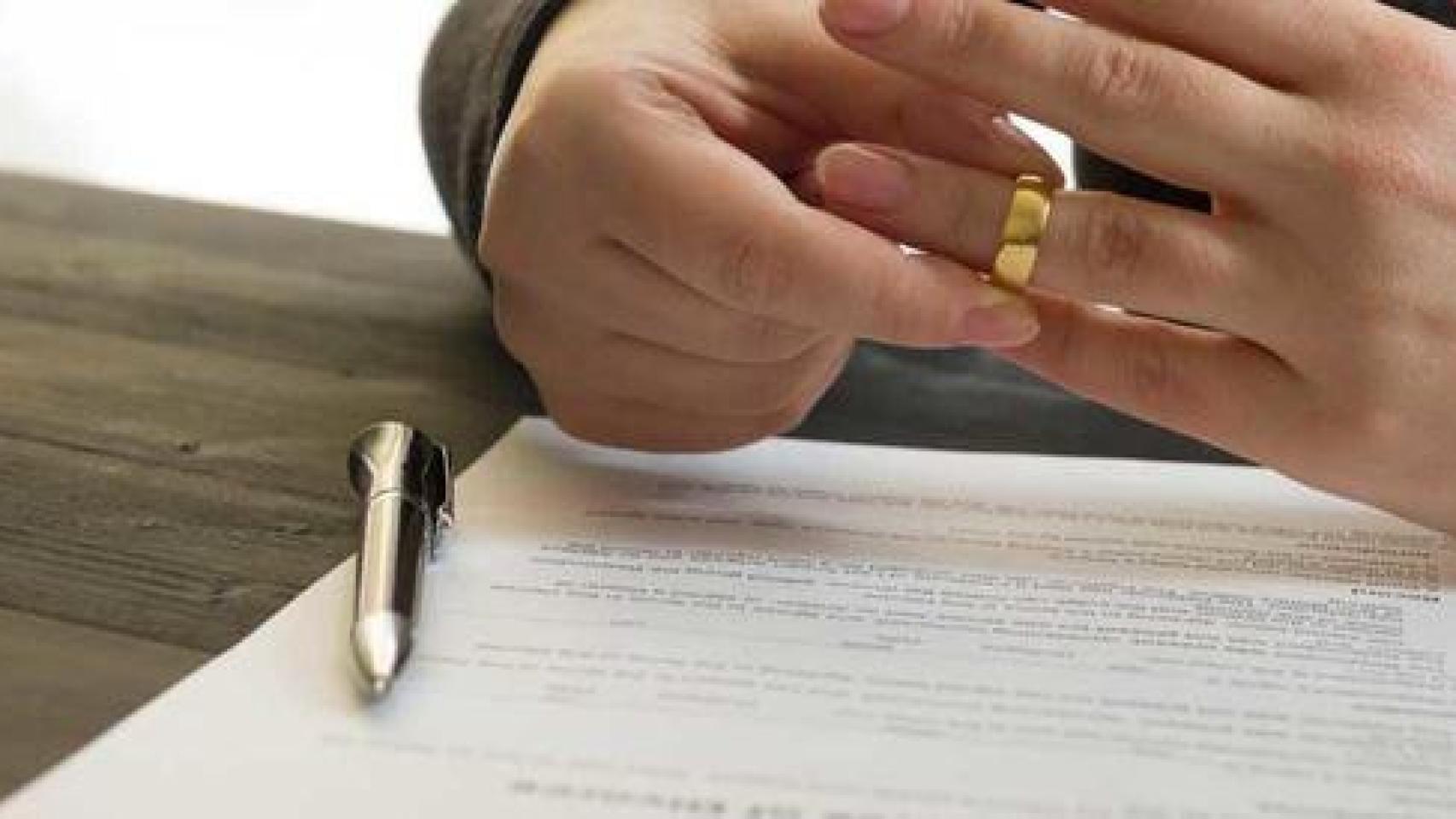 Persona quitándose la alianza matrimonial.