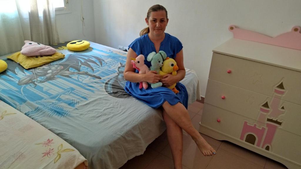 Alina, sentada en la cama de sus hijas Karina y Dalia.