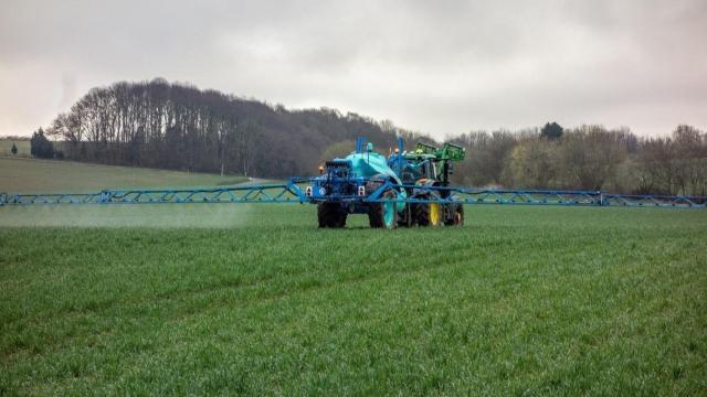 Un agricultor echa fertilizantes a su campo de cultivo