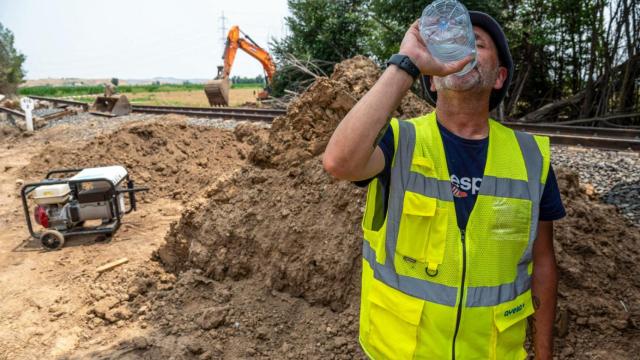 Un operario bebe agua en una obra