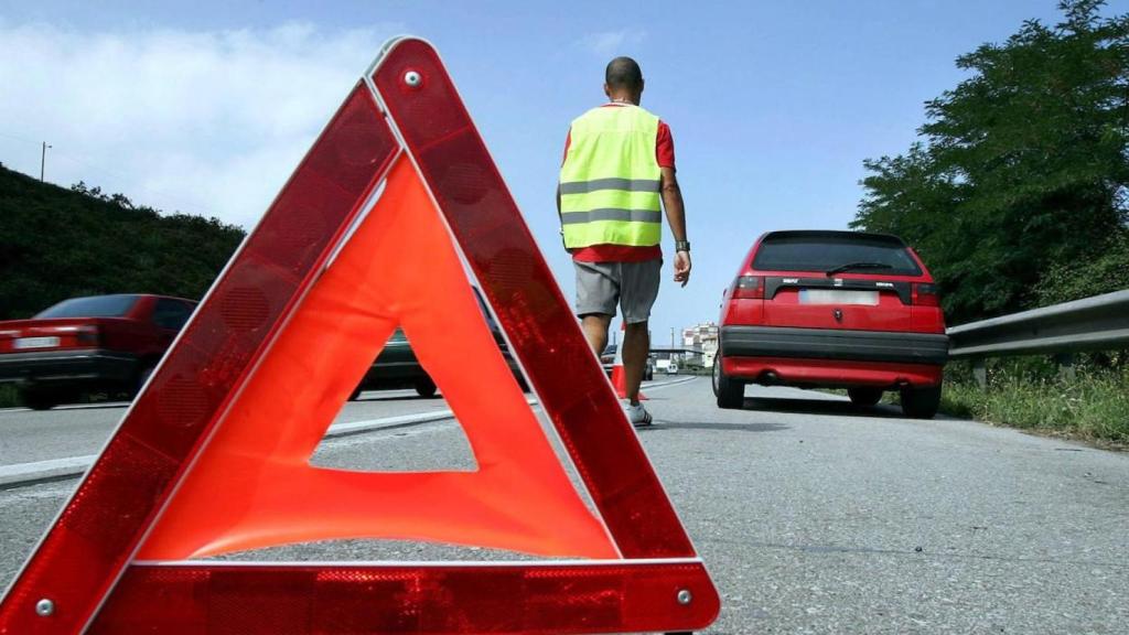 Un hombre se baja de su vehículo tras una avería en la carretera.