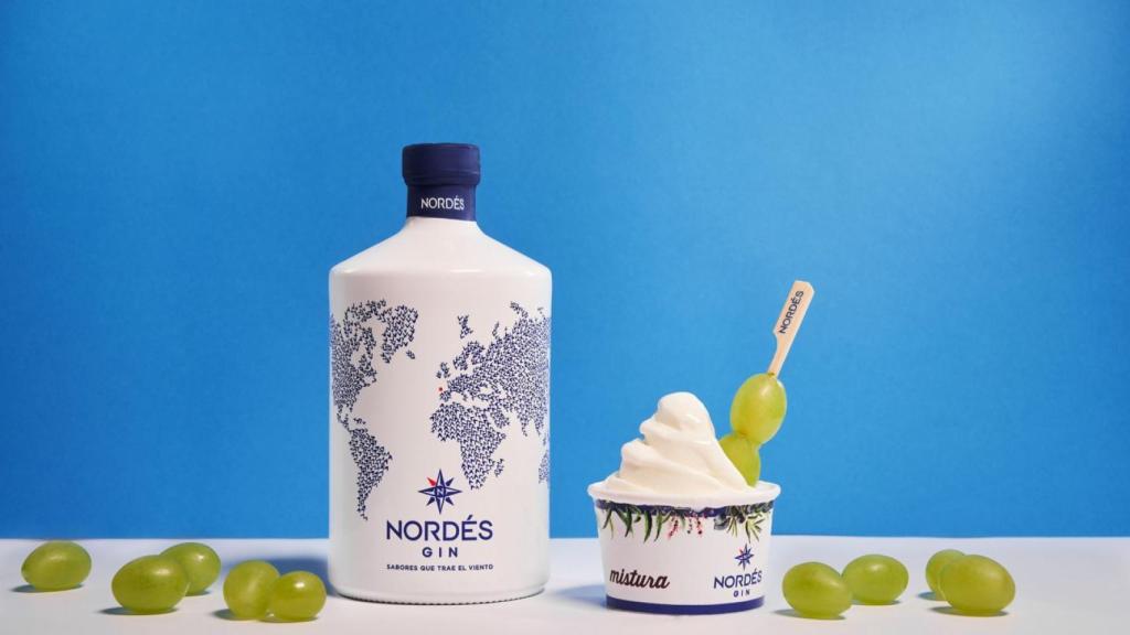 El helado en tarrina terminado con una banderilla de uvas y la botella de la ginebra Nordés.