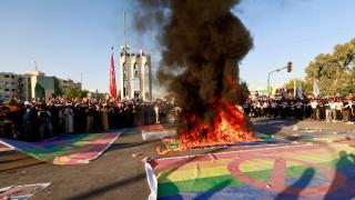 Una bandera LGBT+ arde en llamas durante las protestas en Bagdad, este viernes.