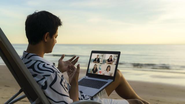 Imagen de archivo de un joven trabajando desde la playa.