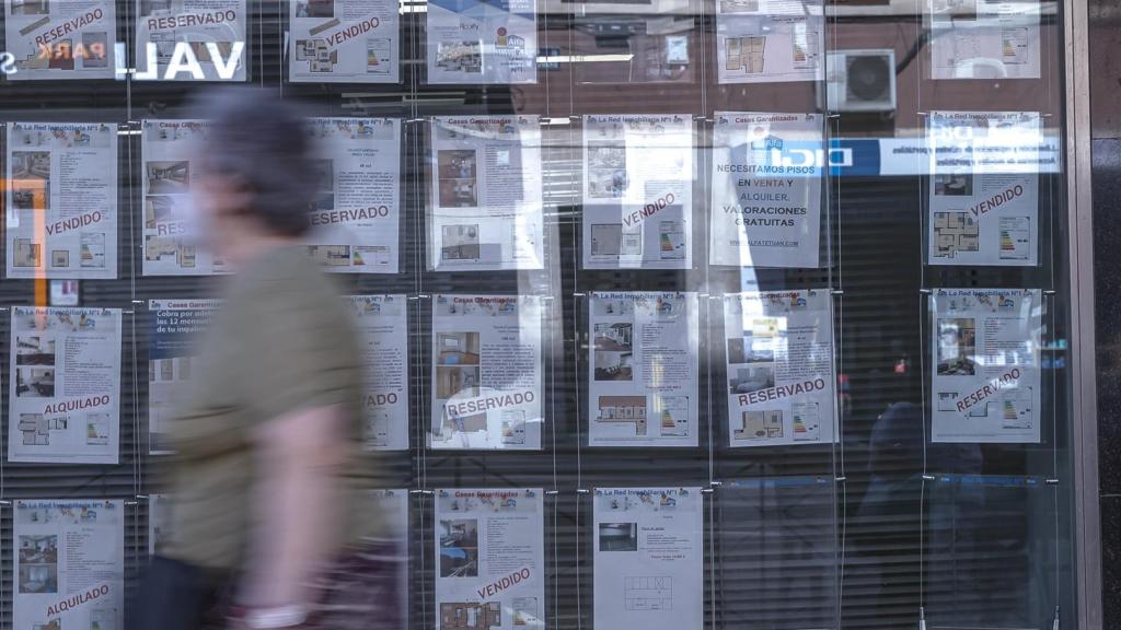 Una persona pasa por delante de una inmobiliaria, en imagen de archivo.