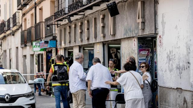 Policías atienden a un familiar de la mujer apuñalada en la tienda de ropa de trabajo ‘Vistebien’, en la plaza de Tirso de Molina.