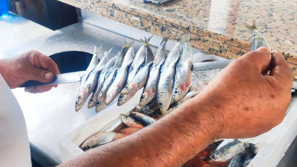 Salvador, del chiringuito Pedro Gutiérrez, ensartando sardinas para espetarlas.