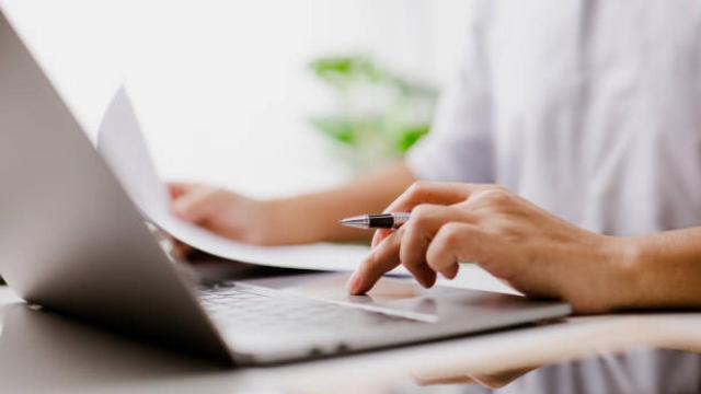 Persona rellenando un formulario frente al ordenador