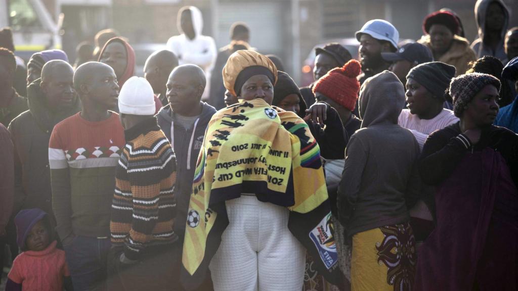 La gente mira a los servicios de emergencia trabajando después de la fuga de gas en Boksburg.