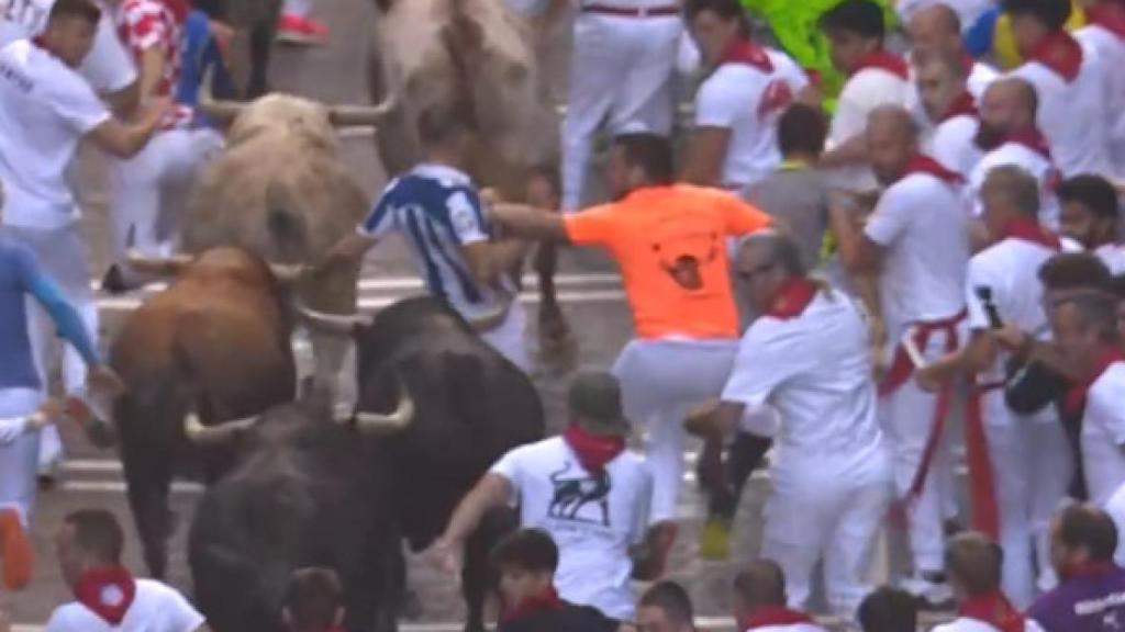 Un corredor empuja a otro durante el cuarto encierro de San Fermín.