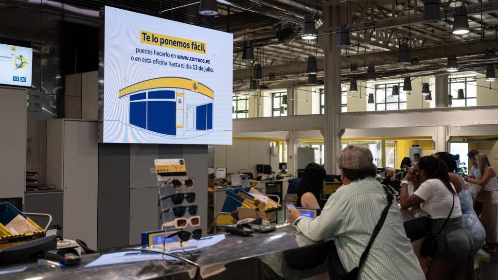 Varias personas esperan a poder enviar su voto por correo en una oficina de correos, a 13 de julio de 2023, en Madrid, (España).